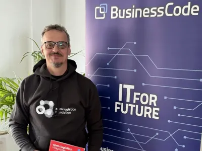 Michael Knümann von BusinessCode im Outfit und mit dem aktuellen Heft der Open Logistics Foundation BusinessCode trägt Expertise zur Open Logistics Foundation bei