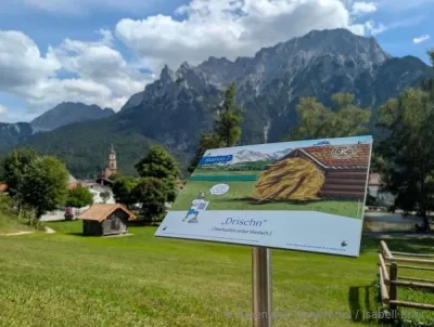 Ein Schild auf dem Mittenwalder Mundartweg - Thema "Wiesmahd" Wandern auf neuen Mundartwegen in der Alpenwelt Karwendel